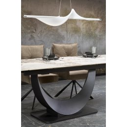 Stół rozkładany z białym marmurem na czarnej, ornamentowej podstawie, w eleganckim jadalnianym wnętrzu z kraciastymi poduszkami.