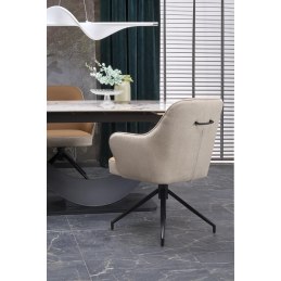 Stół rozkładany z białym marmurem w jadalni, wokół eleganckie krzesła beżowe, czarne metalowe podstawy, żyrandol i rolety w tle.